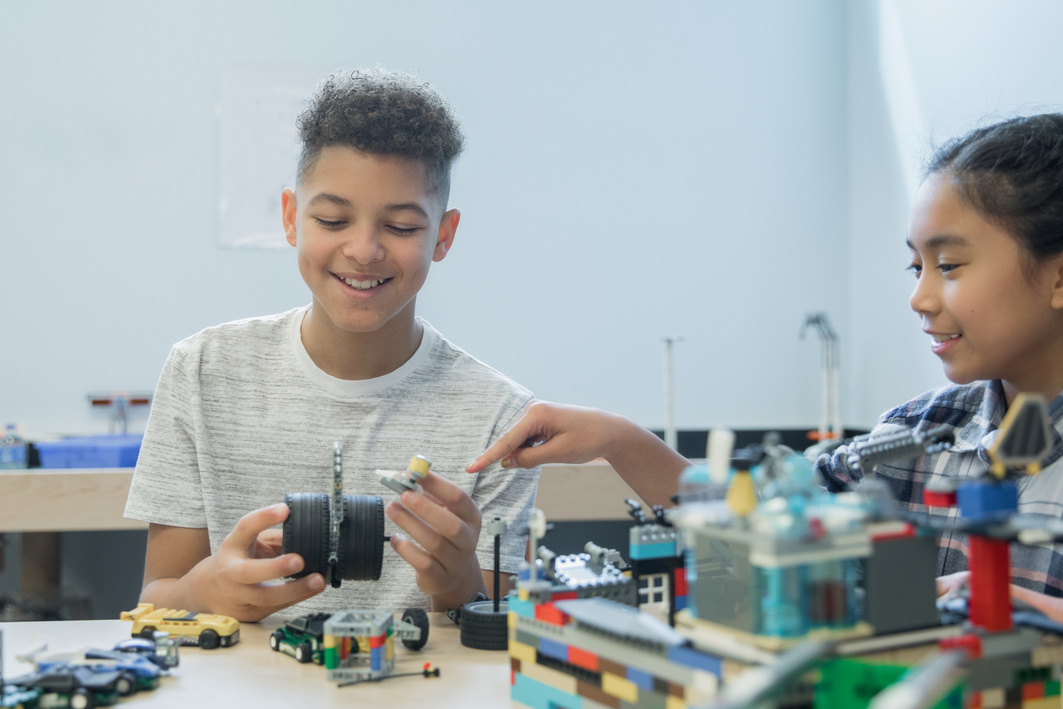 Junior high school students working in STEM makerspace building with robotic kits