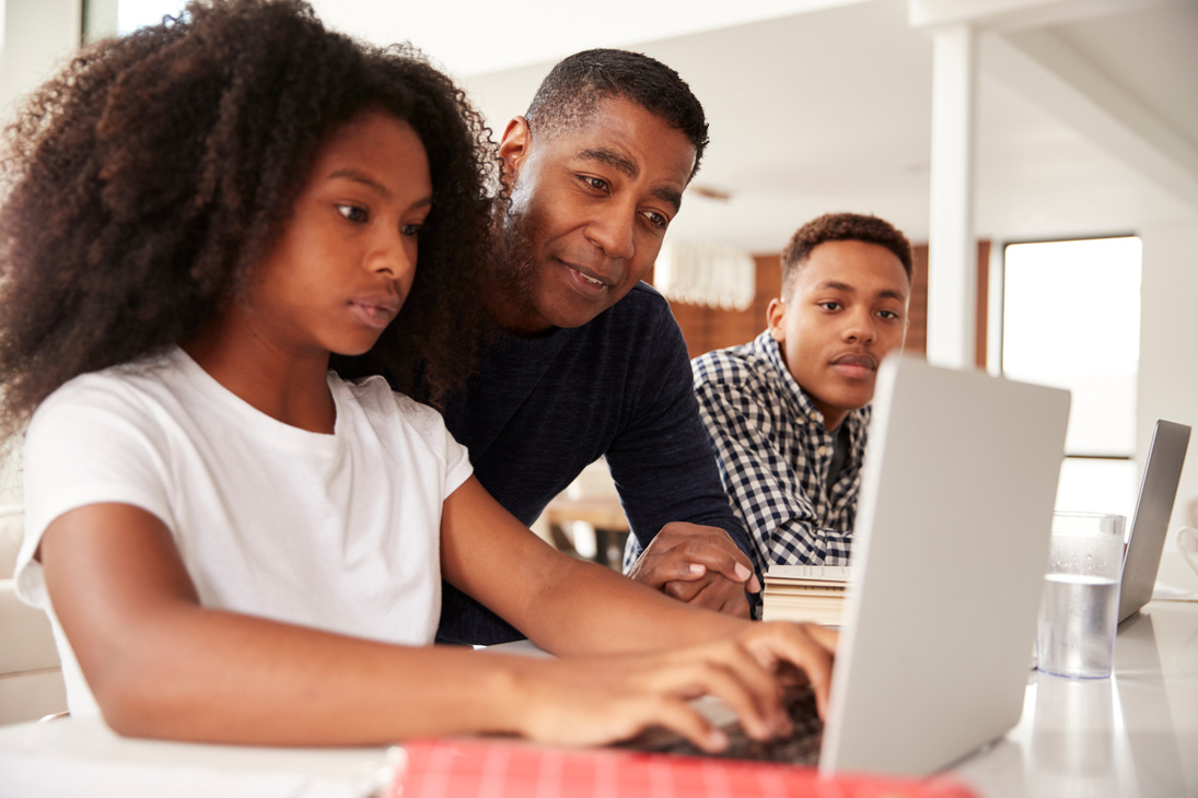 Middle Aged Black Dad Helping His Teen Kids with Homework